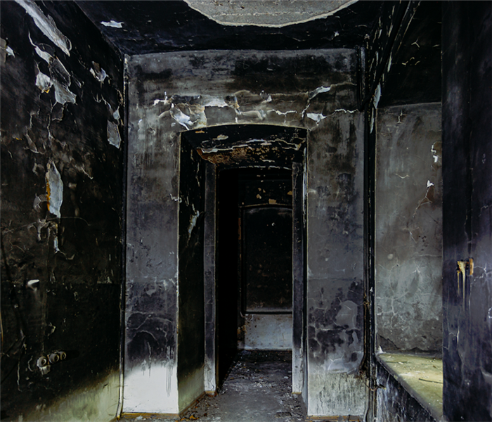 a fire damaged hallway with soot covering the walls and ceiling
